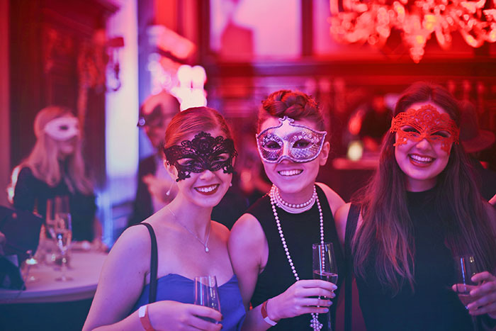 three women posing at a photo booth
